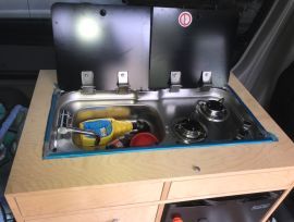 Galley with sink and 2 burner propane stove. Refrigerator is below 